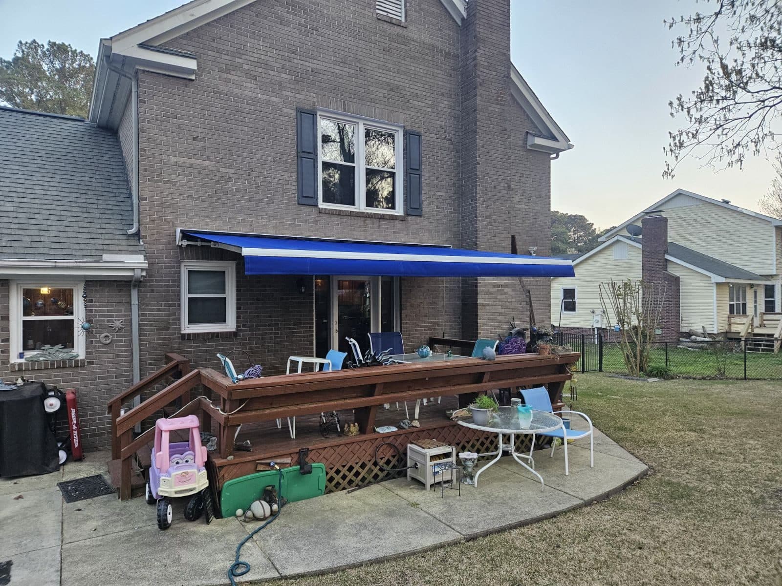 Retractable awning shading a pool house patio