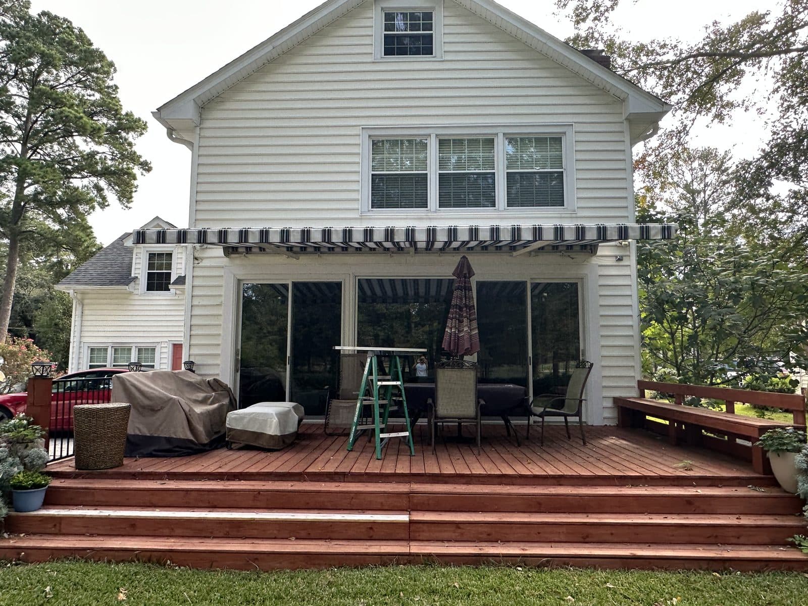 Striped retractable awning over a two-story home deck