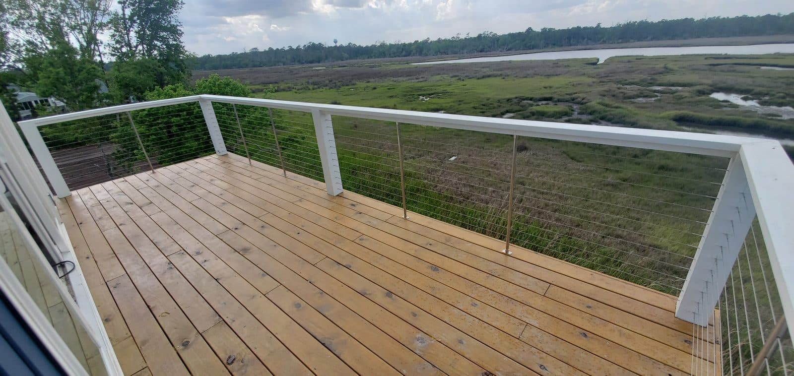 Elevated deck with cable railing overlooking a marsh view